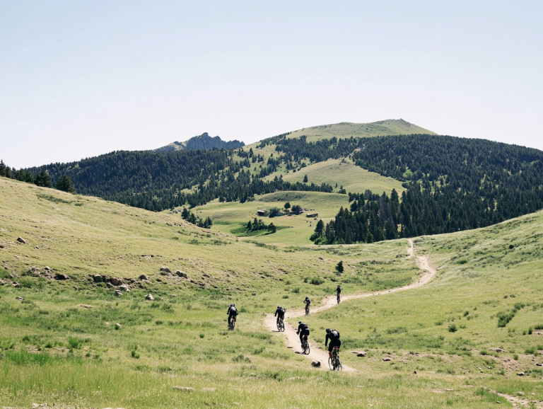 Groupe de cyclistes en VTT traversant un paysage alpin aux Portes du Soleil